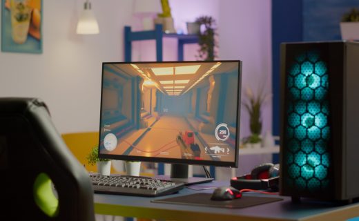 Gaming room no people in equiped with RGB powerful personal computer for online videogames tournament and gaming chair, first-person shooter game on screen. Cozy room with neon light.